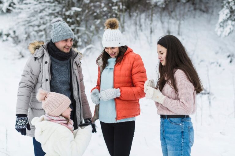 A family dressed in winter clothing spending time together outdoors, symbolizing how parents manage snow day disruptions.